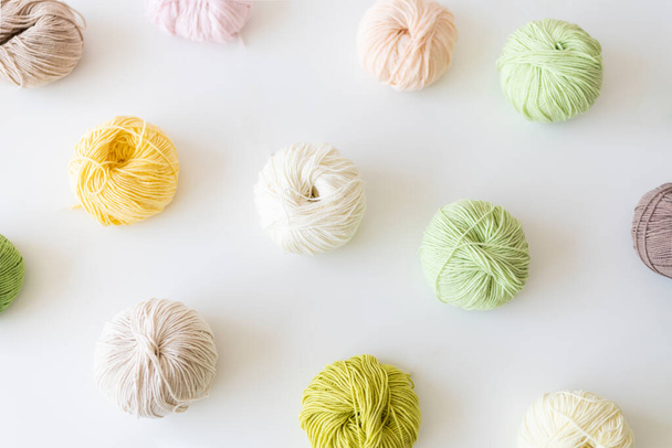 Colored balls of yarn of thread for knitting on a white background. Top view, flat lay. Hobby and hand craft concept. - Foto, imagen