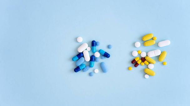 Assorted pharmaceutical medicine pills, tablets and capsules over blue background - Φωτογραφία, εικόνα