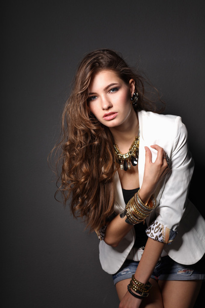 Young beautiful brunette woman  jewelry on grey background - Zdjęcie, obraz
