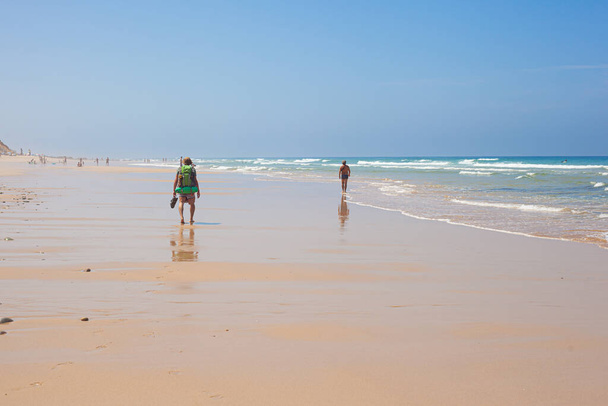 Мандрівник на пляжі Малхао - Фішермани йдуть через Атлантичний океан - Португалія - Фото, зображення
