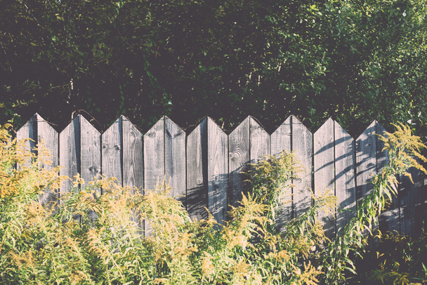 old wooden fence with barbed wire on top - retro, vintage - Foto, afbeelding