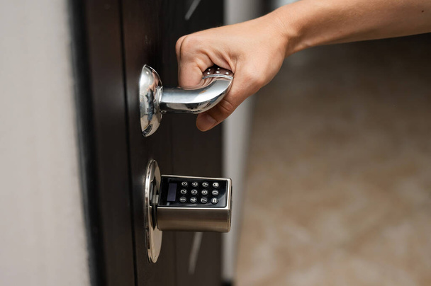 Woman opens the combination lock on the door to the apartment. Keyless entry - Φωτογραφία, εικόνα