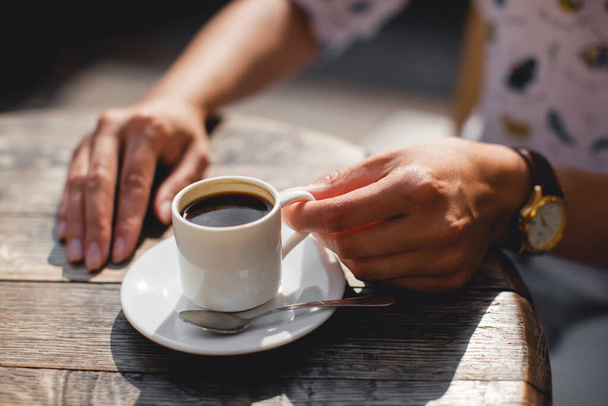 закрыть кружку вкусного ароматного кофе на столе в руках - Фото, изображение