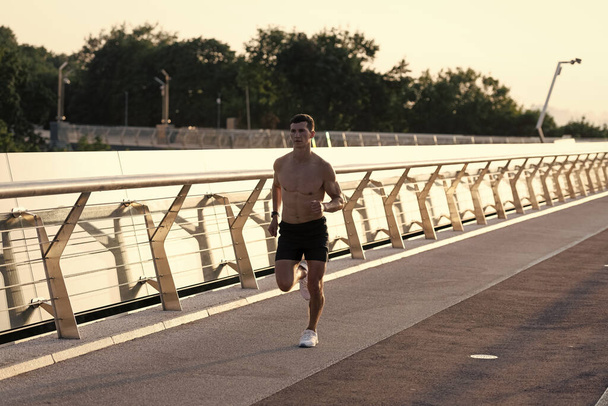 athletic man sprinter with muscular torso running. - Zdjęcie, obraz