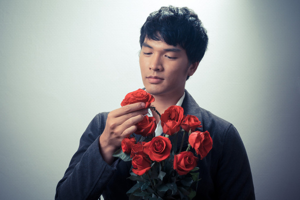Chico asiático con rosas rojas en estilo retro
 - Foto, imagen