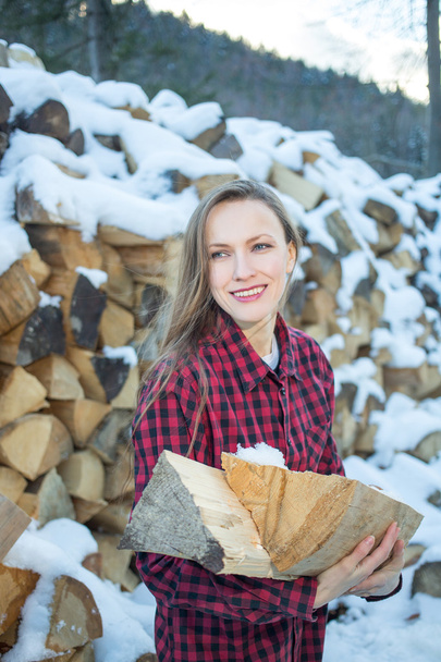 young woman posing with wooden logs for bonfire - Foto, imagen