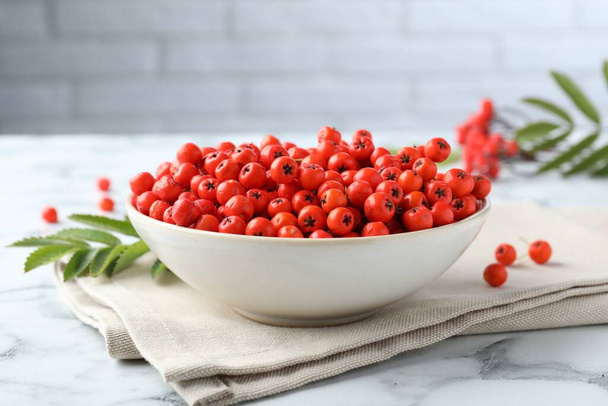 Fresh ripe rowan berries in bowl on white marble table - Foto, Imagem