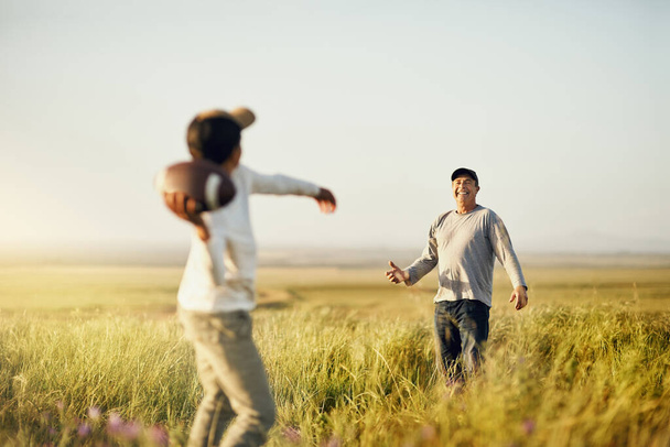 Having our own bonding session. father and son playing football on an open field - Fotoğraf, Görsel