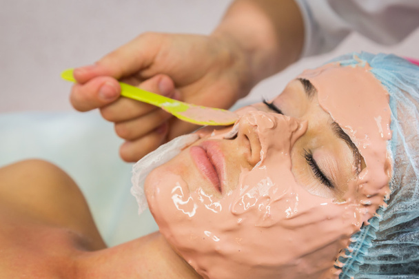 Young woman receiving facial mask - Foto, immagini