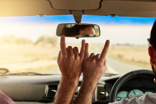 Party on. two unrecognizable men putting their hands together to make a hand sign while driving in a vehicle - Фото, изображение