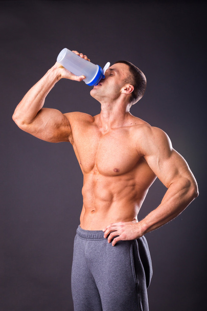 Bodybuilder holding a shaker for drinks - Foto, Bild