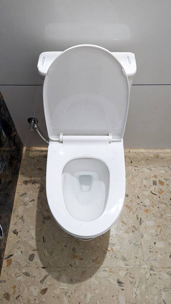 белый туалет с чистым сиденьем, установленным на полу в современной ванной  - Фото, изображение