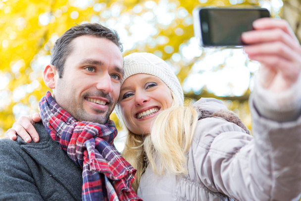Young attractive couple taking selfie in a parc - Fotó, kép