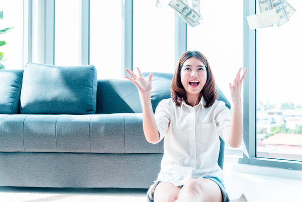 Happy young asian woman holding dollar money and throw in the air celebrate happiness dance wealth lottery money rain drop. Winner Success business woman throw cash flow Happy money smiling face - Foto, Bild