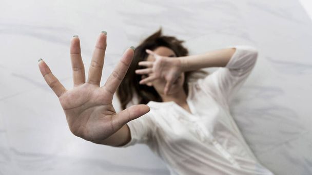 Stop hurting woman! young female person raised her hand for stop violence, sexual abuse, human trafficking, domestic violence and rape, International Day for the Elimination of Violence against Women - 写真・画像