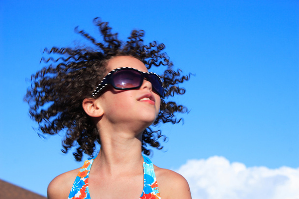 kıvırcık saçlı üfleme ile genç kız - Fotoğraf, Görsel