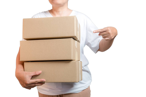A parcel cardboard parcel box in a delivery woman person hands isolated on white background. Delivery service concept. Asian Young girl holding a package is a delivery business entrepreneur. - 写真・画像