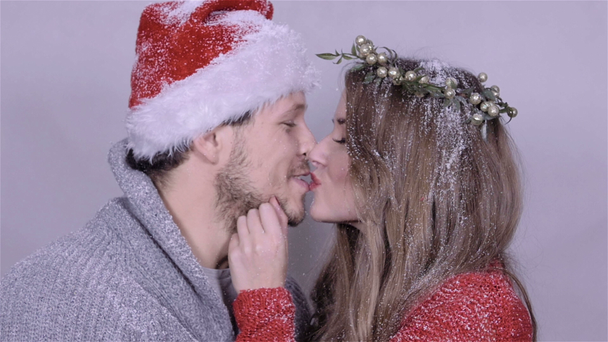 Young Christmas couple enjoying snow over white background. - Video, Çekim