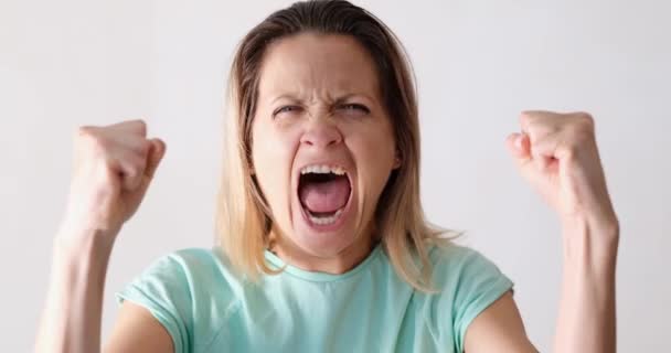 A young woman clenched her fists and yells, close-up. Negative emotions. Womens anger and rage - Filmagem, Vídeo