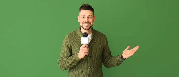 Male journalist with microphone on green background - Photo, image