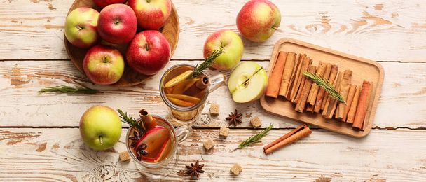 Composition with tasty mulled wine and ingredients on light wooden background, top view - 写真・画像