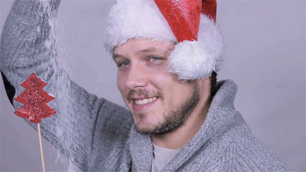 Handsome man in santa claus hat enjoying snow, slow motion. - Materiał filmowy, wideo