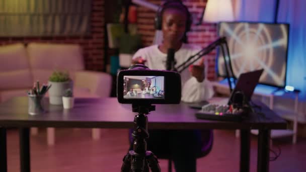 Selective focus on digital video camera screen recording african american vlogger talking to audience from home podcasting studio. Influencer filming herself doing live broadcast for social media. - Séquence, vidéo