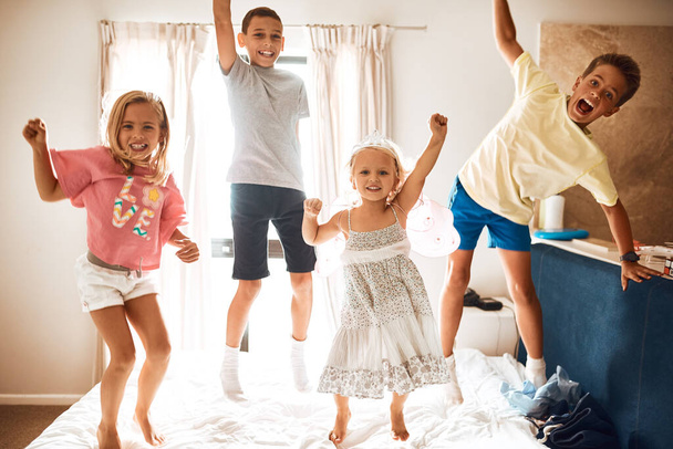 Theyve got endless energy. Portrait of little siblings jumping on a bed at home - Foto, Bild