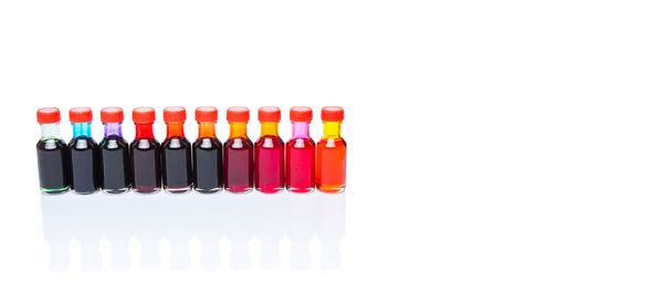 Разнообразие цветов жидких пищевых добавок на белом фоне
 - Фото, изображение