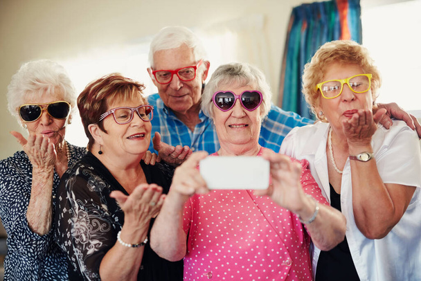 Dont worry about getting old, worry about thinking old. a group of seniors taking a selfie indoors - Foto, Bild