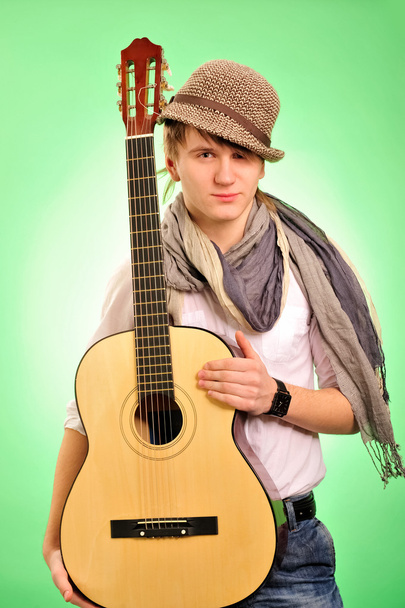 Closeup portrait of cute caucasian man playing the guitar over g - Foto, Imagen