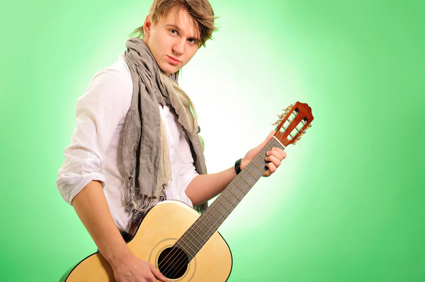 Closeup portrait of cute caucasian man playing the guitar over g - Фото, изображение