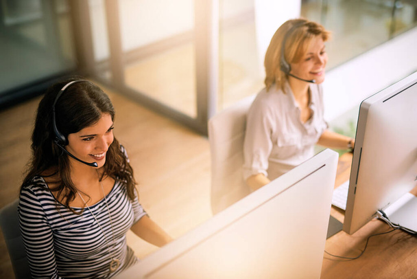 Theyre all about solving problems. High angle shot of two attractive young women working in a call center - Photo, image