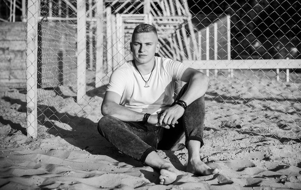 Νεαρός στην παραλία με διάθεση ηρεμίας, ξεκουράζεται στις διακοπές. Καλοκαιρινό πορτρέτο όμορφων ανδρών στην παραλία, έννοια των διακοπών, χρόνος ανάπαυσης  - Φωτογραφία, εικόνα