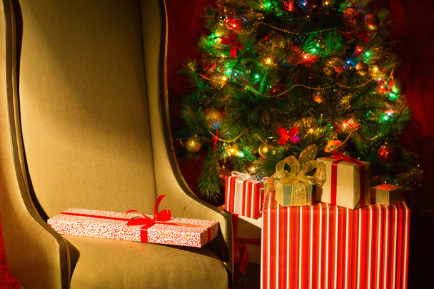 Weihnachtsinterieur mit beleuchtetem Weihnachtsbaum und Stuhl. - Foto, Bild