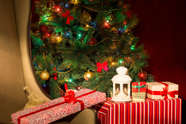 Christmas interior with illuminated Christmas tree and chair. Gi - Photo, Image