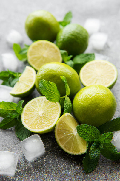 Lime and mint on a dark background. The ingredients for making refreshing drinks and cocktails. - Фото, зображення