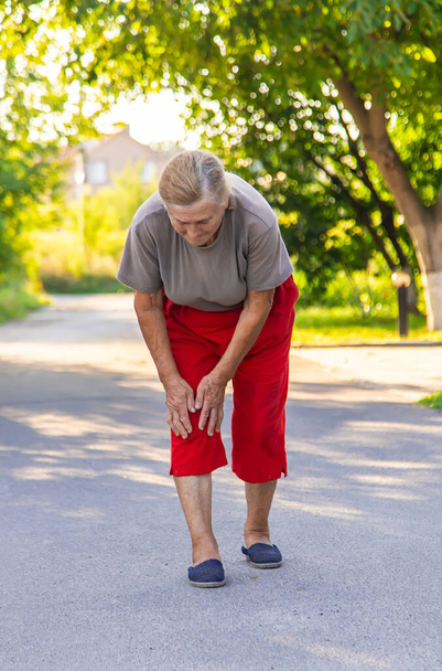grandmother hurts her knee on the road. Selective focus. People. - 写真・画像