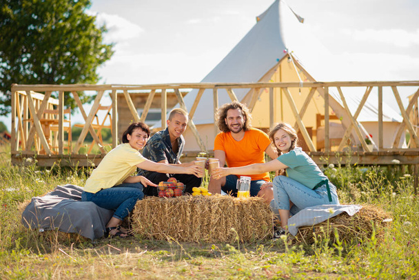 travel, tourism, hike, picnic and people concept - group of happy friends with tent and drinks. - Photo, image