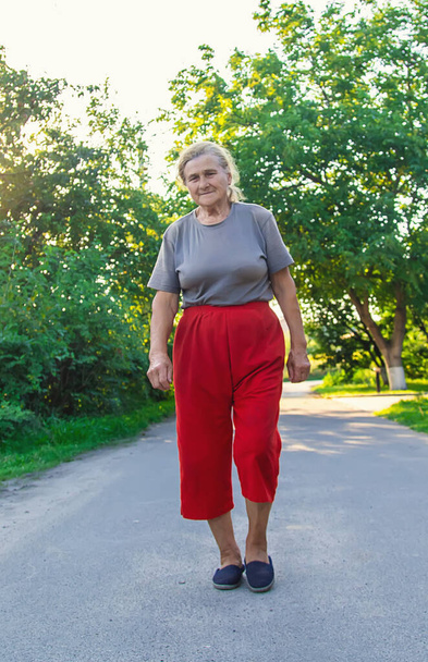 grandma is walking down the road. Selective focus. Nature. - Фото, зображення