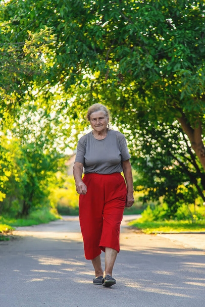 grandma is walking down the road. Selective focus. Nature. - Foto, Bild