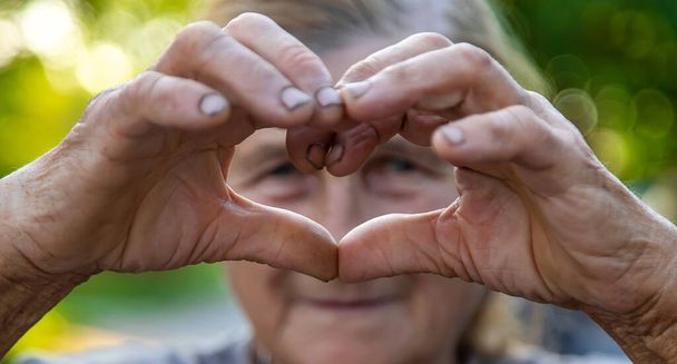 grandmother makes a heart with her hands. Selective focus. People. - Photo, Image