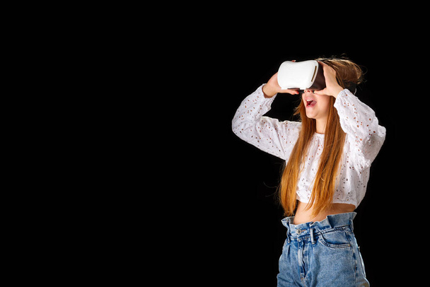 Young woman wearing VR glasses and interacting with virtual reality, entertainment, education and innovative technology concept. goggles to interact with metaverse - Фото, изображение
