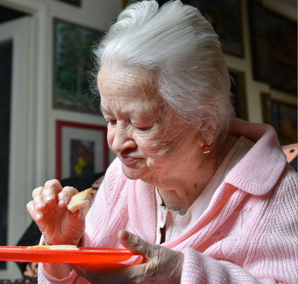 Stara kobieta jedzenie kromka chleba - Zdjęcie, obraz