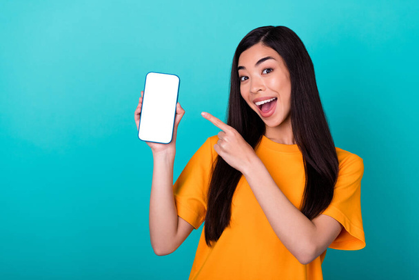 Photo of cool millennial lady index telephone wear orange t-shirt isolated on teal color background. - Foto, afbeelding