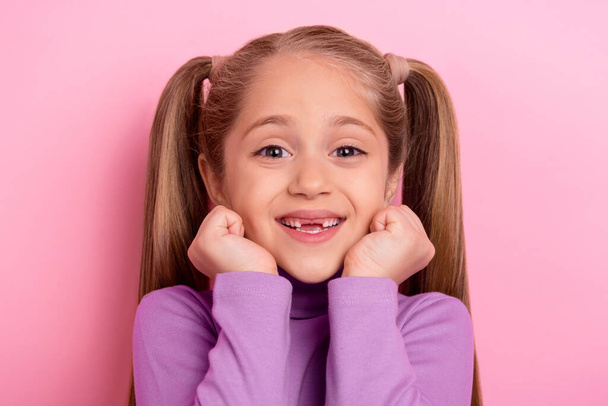 Photo of adorable young girl with two tails hold hands cheeks have no front teeth isolated on pink color background. - Valokuva, kuva