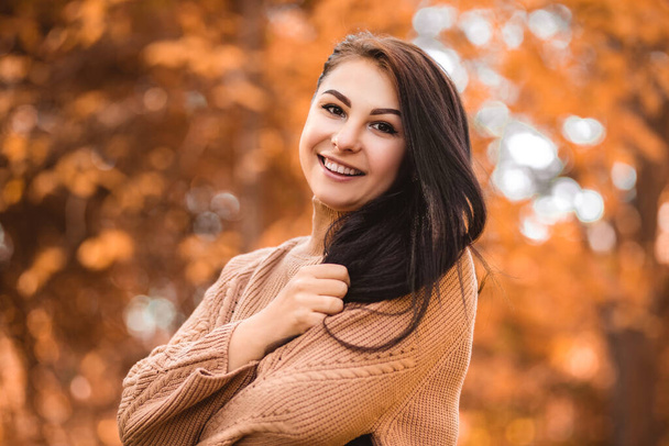 Close up portrait of a smiling happy toothy woman standing in autumn city park forest, looking at the camera open mouth with white teeth. Fall time, red orange and yellow leaves. Blur background - Foto, Bild
