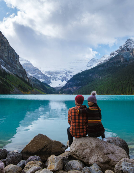 Національний парк Луїза Банф - озеро в Канадських Скелястих горах. Молода пара чоловіків і жінок стоять біля озера під час холодного дня в Канаді. - Фото, зображення