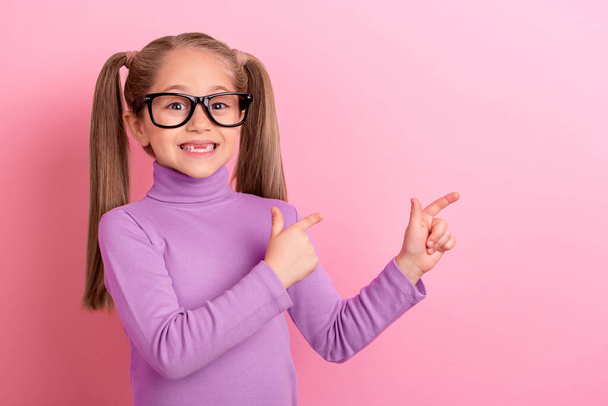 Photo of charming cute little schoolgirl in spectacles promote online courses platform isolated on pink color background. - Zdjęcie, obraz