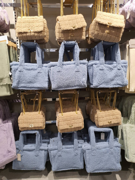 Colorful fluffy plush fabric bags hang on rack in clothing store. Trendy fall winter style. Woman clothes, accessories, bag trends. handbags, shoulder bags and purses fashion concept - 写真・画像